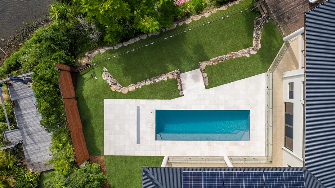 Long narrow fibreglass lap pool running down the side of a home